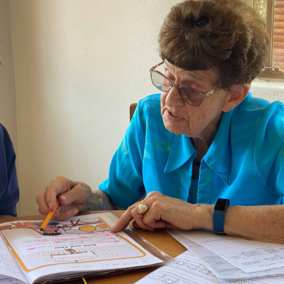 Teacher Tiensie reading with learner